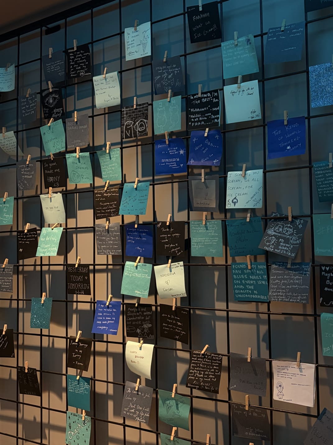 a whole wall of notes, pegged up to dry
